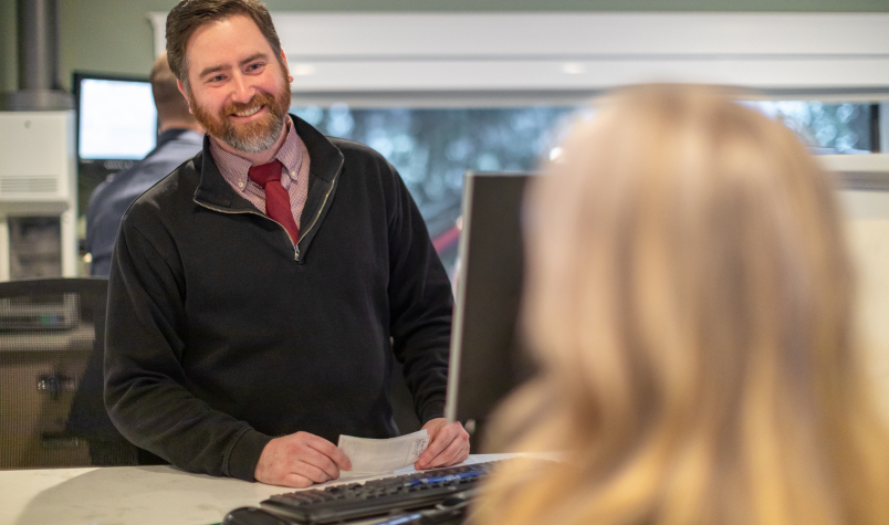 GSB Banker Smiling at Customer in Branch Office